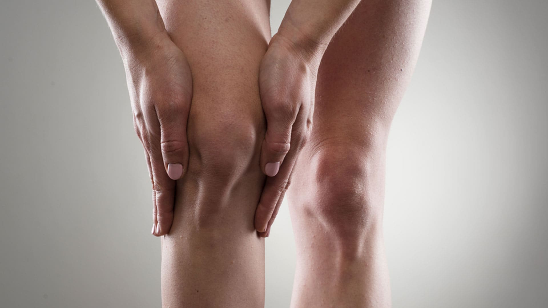 Fysio Ter Horst Artrose knie heup: twee handen houden een pijnlijke knie vast.