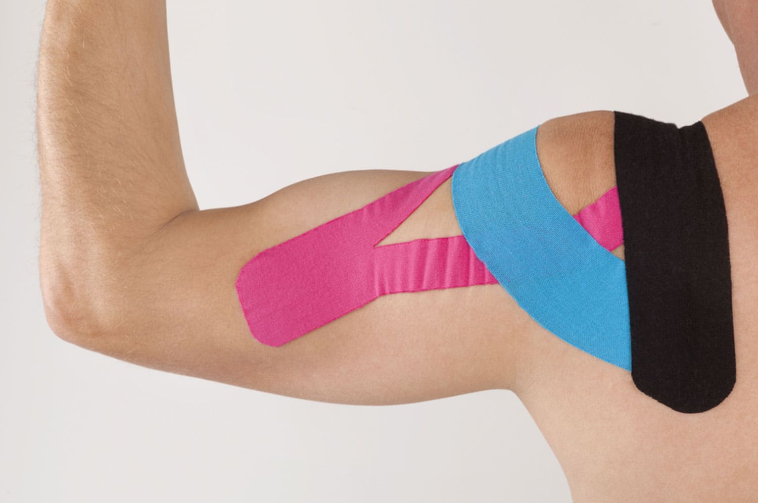 Kinesiotape is aangebracht op de schouder van een cliënt.